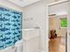 Bathroom featuring a shark-themed shower curtain and a view to an adjacent living space with a door to the exterior at 1710 Alvarado Ct, Longwood, FL 32779
