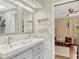 Bathroom with a double sink vanity, modern lighting, and access to an adjacent bedroom at 1710 Alvarado Ct, Longwood, FL 32779