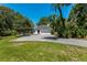 Home exterior with a large driveway, attached garage, and well-manicured lawn surrounded by mature trees at 1710 Alvarado Ct, Longwood, FL 32779