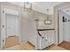 Hallway featuring decorative light fixtures, staircase, and access to multiple rooms at 1710 Alvarado Ct, Longwood, FL 32779
