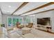 Open living room with wooden beams, hardwood floors, and glass patio doors at 1710 Alvarado Ct, Longwood, FL 32779
