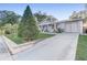 A cozy home with a well-kept lawn, a long driveway, and mature trees surrounding the property at 1905 Lady Ave, Ocoee, FL 34761