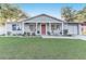 Charming home with a covered front porch, classic rocking chairs, and beautiful landscaping at 1905 Lady Ave, Ocoee, FL 34761
