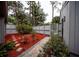 A lush backyard space features colorful ground cover and a paved path to the gate at 207 Sweet Gum Way, Longwood, FL 32779