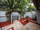 Backyard patio featuring an arched gate, stone pathway, and mature trees at 207 Sweet Gum Way, Longwood, FL 32779
