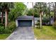 Charming home featuring a two car garage with a dark blue door, beautiful landscaping, and a paved driveway at 207 Sweet Gum Way, Longwood, FL 32779