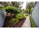 Inviting entryway with a walkway through manicured shrubs and a view of the garage at 207 Sweet Gum Way, Longwood, FL 32779