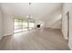 Well-lit living room with wood-look floors, stone fireplace, and sliding glass doors to the patio at 207 Sweet Gum Way, Longwood, FL 32779