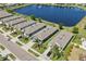 Aerial view of homes with manicured lawns, lush landscaping, and a large lake with a fountain feature at 2907 Sime St, New Smyrna Beach, FL 32168