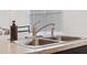 Stainless steel kitchen sink with a modern faucet and sprayer, set in a neutral countertop at 2907 Sime St, New Smyrna Beach, FL 32168