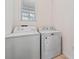 Laundry room with white washing machine and dryer near a window at 2907 Sime St, New Smyrna Beach, FL 32168