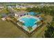 Aerial view of a luxurious community pool with a covered pavilion, surrounded by palm trees and lush landscaping at 2907 Sime St, New Smyrna Beach, FL 32168