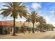 A charming street view with palm trees, shops, and parked cars under a sunny blue sky at 2907 Sime St, New Smyrna Beach, FL 32168