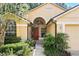 Inviting home entrance framed by lush landscaping and featuring a stylish red front door at 2987 Sabel Oak Pl, Oviedo, FL 32765