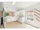 Open kitchen with white cabinetry, neutral tile floor, view to living room, and white appliances at 2987 Sabel Oak Pl, Oviedo, FL 32765