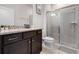 Modern bathroom featuring granite countertop, dark wood cabinetry, and glass-enclosed shower at 301 Jetty Way, Davenport, FL 33897