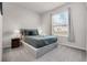 Bedroom featuring a queen-sized bed with neutral tones, bedside lamps, and a bright window at 301 Jetty Way, Davenport, FL 33897