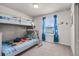 Neutral ' bedroom with a twin bunk bed and window with blue curtains at 301 Jetty Way, Davenport, FL 33897