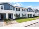 Exterior view of townhomes featuring blue siding, manicured lawns, and well-maintained landscaping at 301 Jetty Way, Davenport, FL 33897