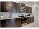 Well-equipped kitchen with modern appliances, dark wood cabinets, and stylish backsplash, offering both style and practicality at 301 Jetty Way, Davenport, FL 33897