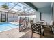 Inviting screened-in pool area with dining set, lounge chairs, and a safety fence at 301 Jetty Way, Davenport, FL 33897