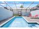 Private pool area with red lounge chairs inside a screened-in enclosure at 301 Jetty Way, Davenport, FL 33897
