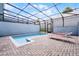 Inviting pool with red lounge chairs inside a screened-in enclosure at 301 Jetty Way, Davenport, FL 33897