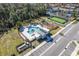 Aerial view of community pool with lounge chairs, a soccer field, and a playground in a park setting at 3191 Paradox Cir # 401, Kissimmee, FL 34746