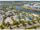 Aerial view of a resort-style pool featuring a lazy river, water slides, and lush landscaping, near a lake at 3191 Paradox Cir # 401, Kissimmee, FL 34746