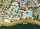 Aerial view showcasing a community pool with water features and sports facilities near a scenic lake at 3191 Paradox Cir # 401, Kissimmee, FL 34746