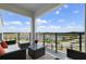 Relaxing balcony featuring comfortable seating, a glass table, and picturesque water fountain and lake views at 3191 Paradox Cir # 401, Kissimmee, FL 34746