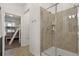 Bright bathroom featuring a glass shower, with a view of the bedroom bunk beds and neutral tile flooring at 3191 Paradox Cir # 401, Kissimmee, FL 34746