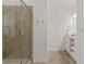 Clean bathroom featuring a glass-enclosed shower, neutral tile, and a white vanity with ample storage at 3191 Paradox Cir # 401, Kissimmee, FL 34746