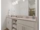 Bright bathroom with double sinks, white cabinets, quartz countertops and a view of the glass shower at 3191 Paradox Cir # 401, Kissimmee, FL 34746