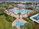 Aerial view of the resort style community pool, splashpad and seating area surrounded by lush landscaping at 3191 Paradox Cir # 401, Kissimmee, FL 34746