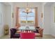 Formal dining area featuring a glass-top table, plush chairs, elegant chandelier, and natural light at 3191 Paradox Cir # 401, Kissimmee, FL 34746