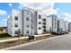 Beautiful three-story condo building with gray and white exterior paint and landscaping at 3191 Paradox Cir # 401, Kissimmee, FL 34746