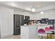 Bright kitchen featuring sleek appliances, white cabinets, gray subway tile backsplash, and island seating at 3191 Paradox Cir # 401, Kissimmee, FL 34746