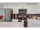 Close-up of a modern kitchen featuring stainless steel appliances, white quartz countertop, and stylish backsplash at 3191 Paradox Cir # 401, Kissimmee, FL 34746