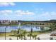 Scenic view of a beautiful lake with a fountain, palm trees, and modern buildings in the background at 3191 Paradox Cir # 401, Kissimmee, FL 34746