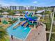 Aerial view of community water slides and pool area with lush landscaping and seating at 3191 Paradox Cir # 401, Kissimmee, FL 34746