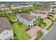 Aerial view showcases a home with a well-manicured lawn, a pool, and a paver driveway at 321 Falls Dr, Kissimmee, FL 34747