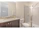 Well-lit bathroom featuring a tiled shower, toilet, and granite countertop vanity at 321 Falls Dr, Kissimmee, FL 34747