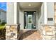 Inviting front entrance with a decorative glass door, stone pillars, and brick paver walkway at 321 Falls Dr, Kissimmee, FL 34747