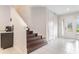Welcoming home foyer featuring tile floors, a staircase, and a decorative glass front door at 321 Falls Dr, Kissimmee, FL 34747