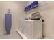Well-organized laundry room with new washer and dryer, ironing board, and storage shelves at 321 Falls Dr, Kissimmee, FL 34747