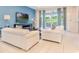 Modern living room with stylish sofas, a flat-screen TV, and sliding glass doors to the outdoor patio at 321 Falls Dr, Kissimmee, FL 34747