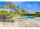 Backyard pool and spa with lush landscaping, privacy fence, and lounge chairs at 321 Falls Dr, Kissimmee, FL 34747