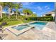 Pool and spa with a brick surround, set in a spacious backyard with manicured landscaping at 321 Falls Dr, Kissimmee, FL 34747