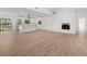 Open-concept living space boasts new floors, white brick fireplace and flows seamlessly into a modern white kitchen at 345 W Hornbeam Dr, Longwood, FL 32779